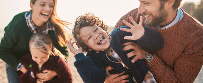 Young family laughing and playing outdoors